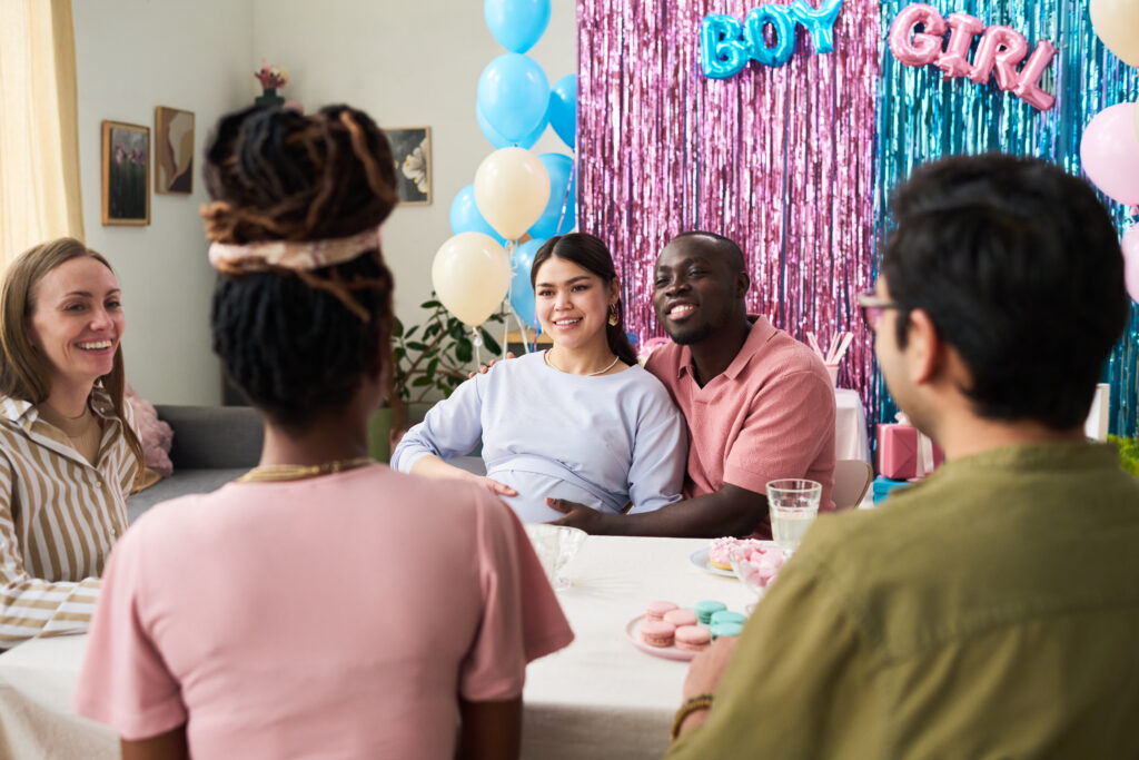 multiethnic group of young adults and one pregnant asian woman sitting around table multiethnic group of young adults and one pregnant asian woman sitting around table